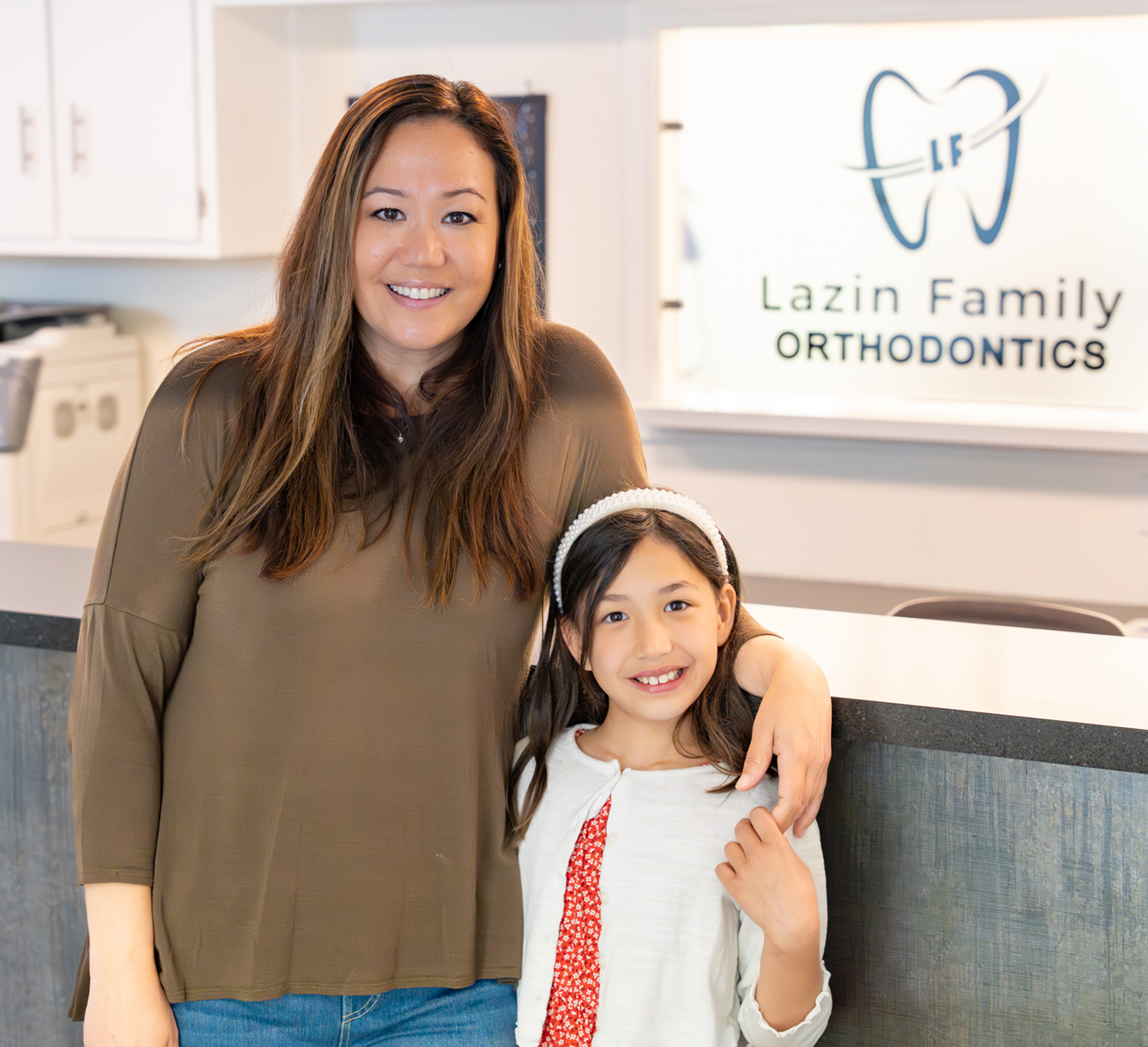 Smiling mother and young daughter in the Lazin Family Orthodontics lobby